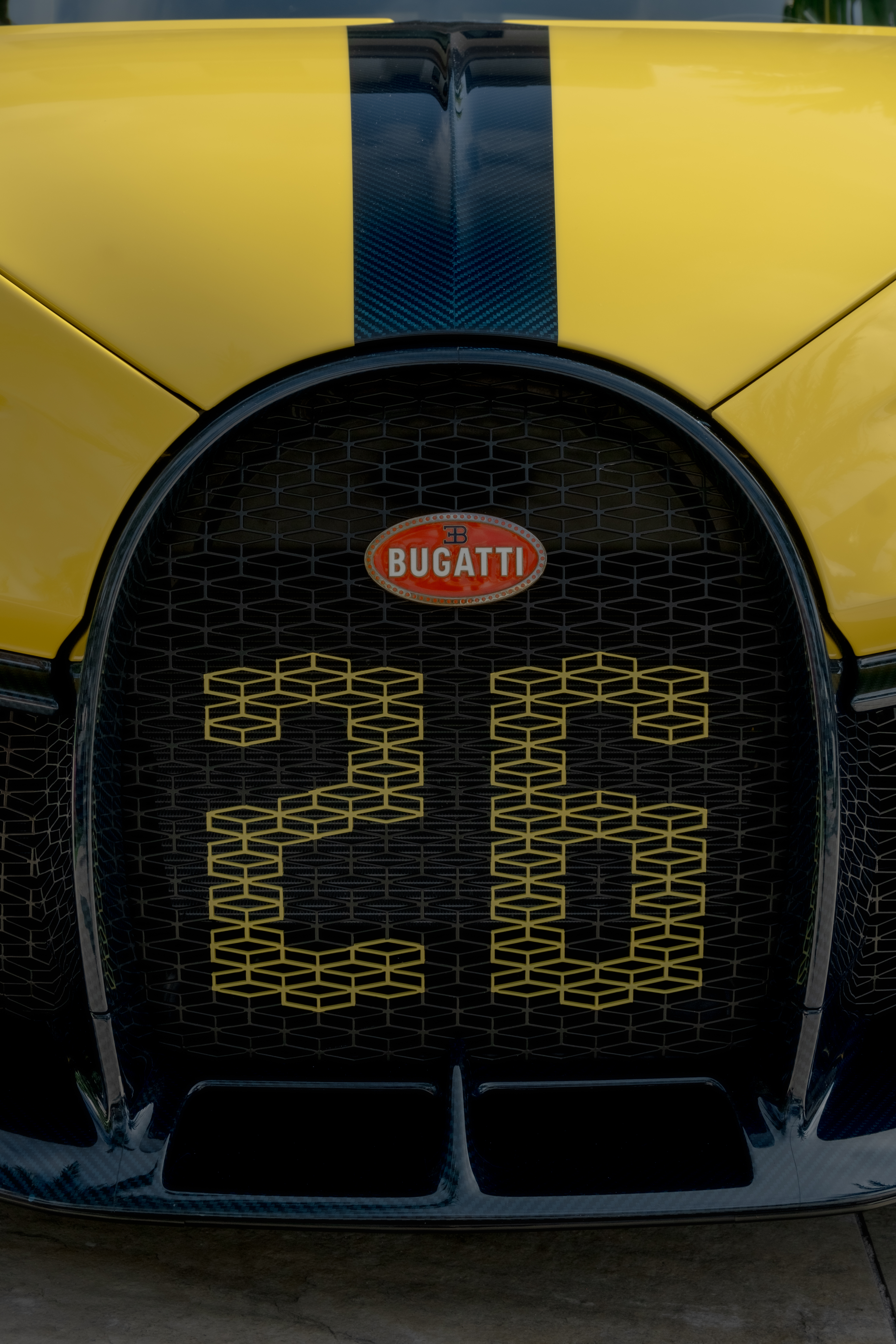 “Ferrari logo close-up on carbon fiber hood during luxury automotive photo session.”